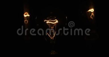 一盏白炽灯的美丽纹理被两个<strong>舞动</strong>的倒影照亮。